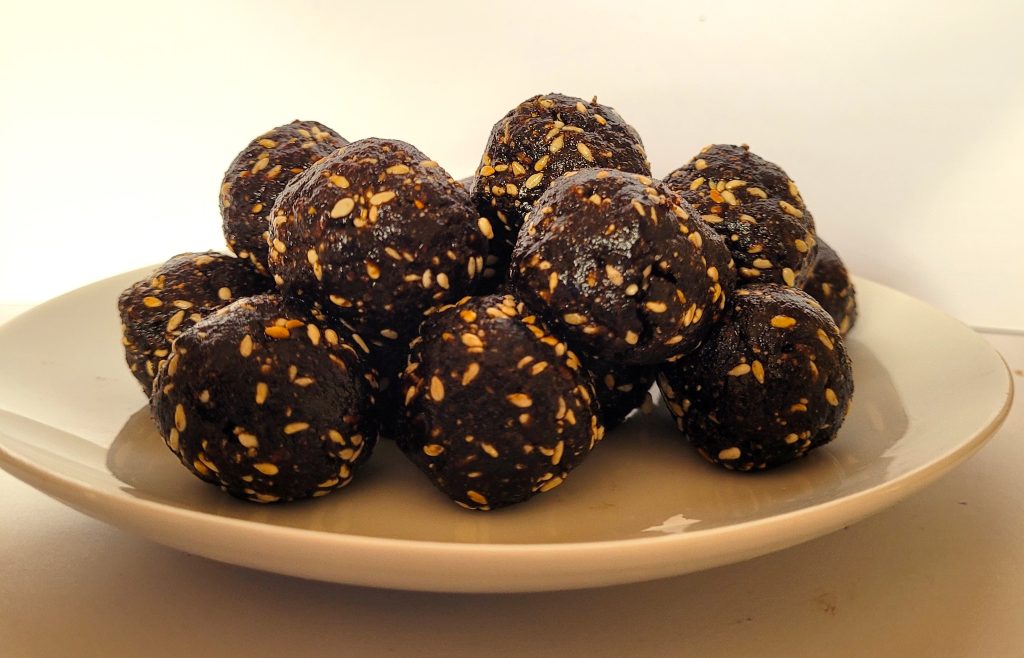 Plate of fresh, homemade bliss balls spiced with magnolia petals