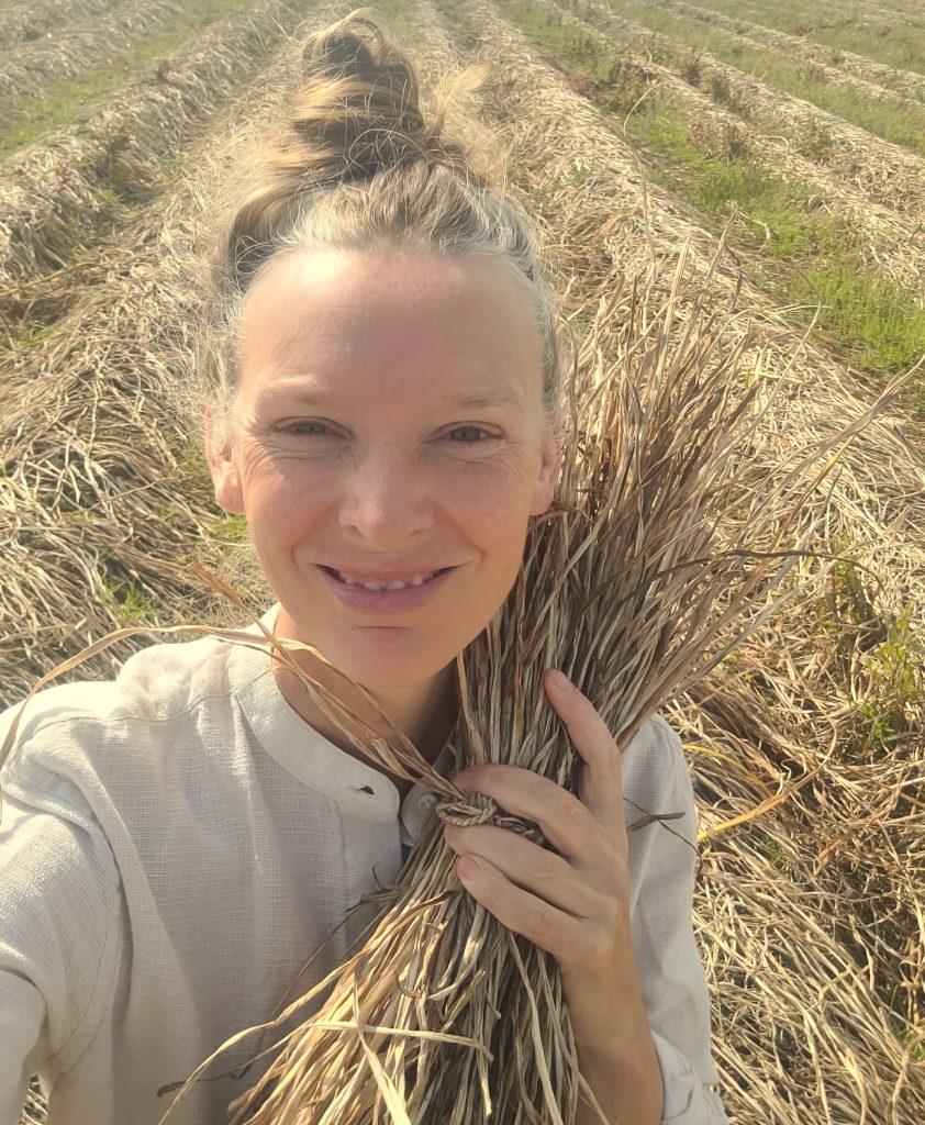 Forager Rachel Lambert standing in a field with gleened daffodil stems